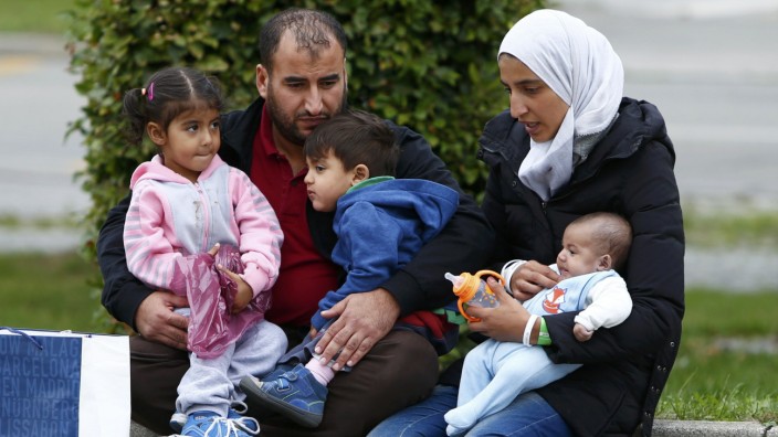 A migrant family from Syria is seen outside a refugee camp at the fair ground of Munich