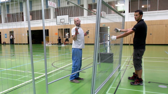 Asylbewerber in der Turnhalle: Damit eine Turnhalle zum Schlafsaal werden kann, werden wie hier in der Freisinger Wirtschaftsschule Trennwände aufgestellt.