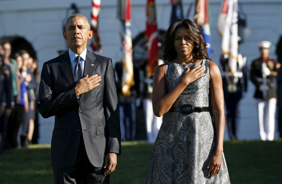 U.S. President Barack Obama and first lady Michelle Obama observe a moment of silence on the South Lawn of the White House to mark the 14th anniversary of the 9/11 attacks, in Washington