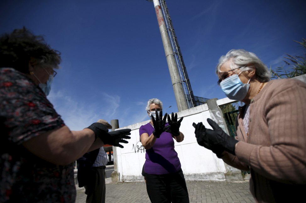 Women put gloves and masks on during a graffiti class offered by the LATA 65 organization in Lisbon
