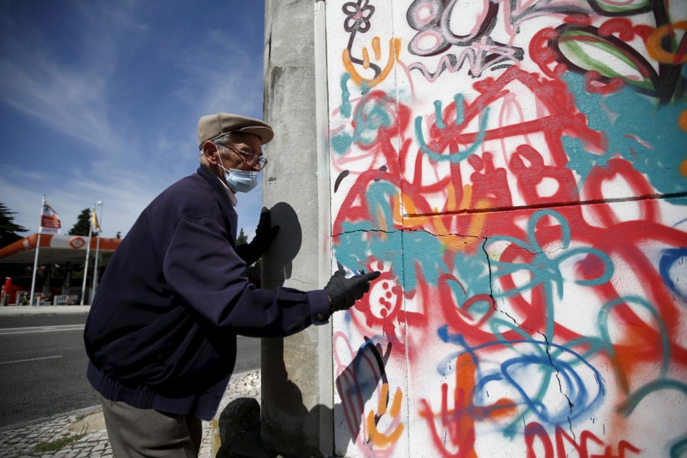 Hugo, 85, sprays on a wall during a graffiti class offered by the LATA 65 organization in Lisbon