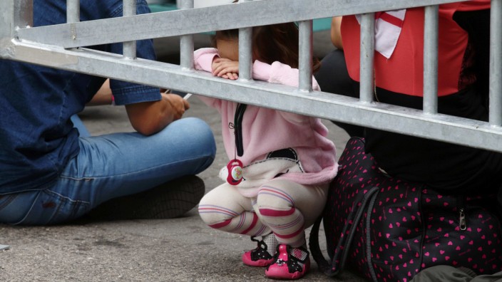 A migrants' child leans to a fencing as they wait for trains at Westbahnhof railway station in Vienna