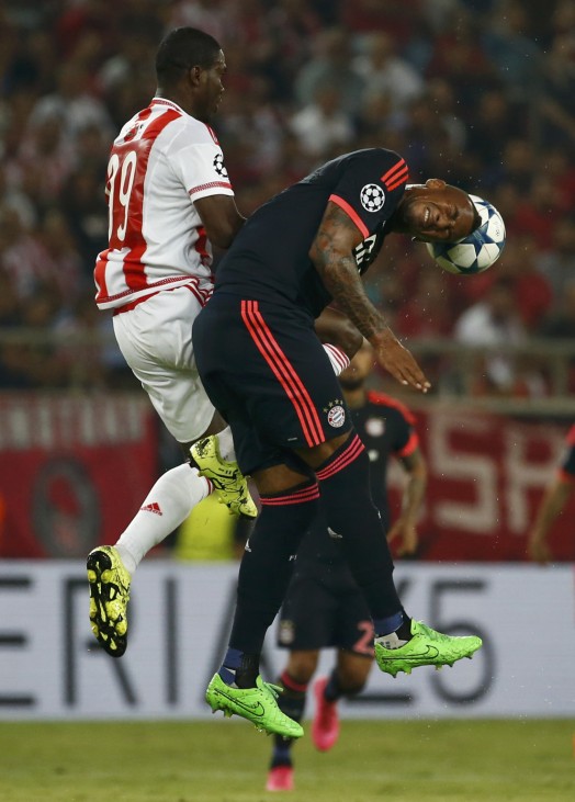 Bayern Munich's Boateng jumps for a header with Olympiacos' Brown during their Champions League group F soccer match against Olympiacos at the Karaiskakis stadium in Piraeus
