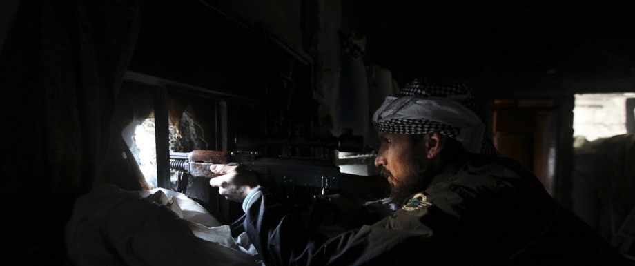 A Free Syrian Army fighter sits in shooting position in Deir al-Zor, eastern Syria