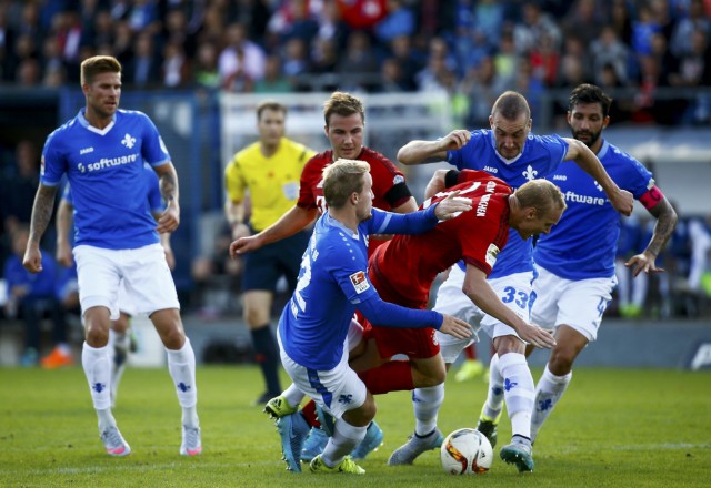 Bayern Munich's Goetze and Rode are checked by Darmstadt 98 Holland and Caldirola during their German first division Bundesliga soccer match in Darmstadt