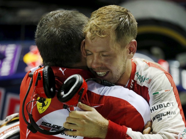 Ferrari Formula One driver Vettel of Germany hugs a team mate after winning the Singapore F1 Grand Prix