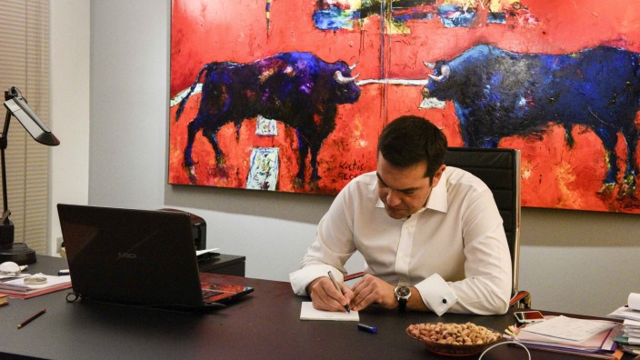 Leftist Syriza party leader and winner of the Greek general elections Tsipras writes down notes at this office at the party's headquarters in this handout photo released by the Syriza press office in Athens