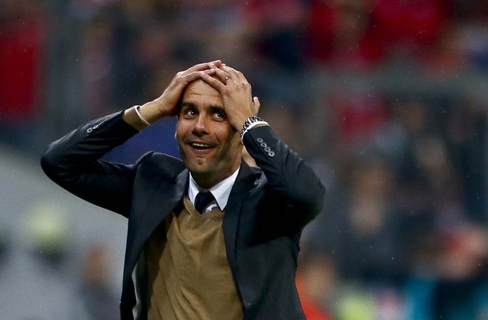 Bayern Munich's coach Guardiola reacts after his team scored a goal during their German first division Bundesliga soccer match against Wolfsburg in Munich