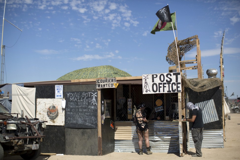 People stand at a post office during Wasteland Weekend event in California City