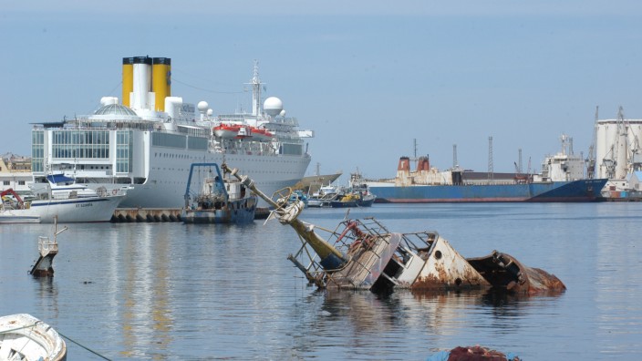 Zauberformel "Umrouten": Die Costa Marina 2005 beim Erstanlauf im Hafen von Tripolis (Libyen). Die Wracks im Vordergrund sind Ergebnisse der Bombardierungen in den Vorjahren.