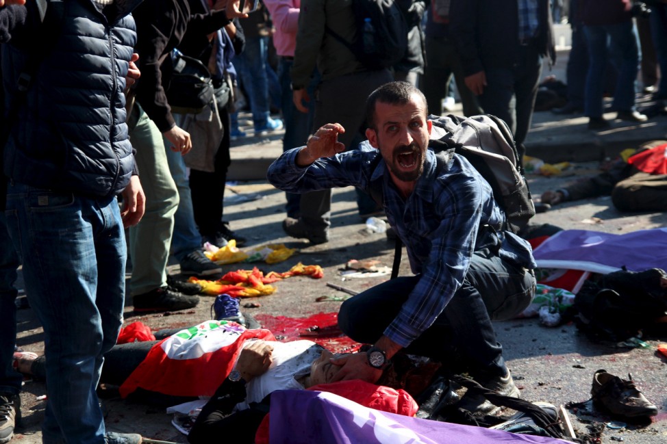 A man asks for help for an injured woman after an explosion during a peace march in Ankara