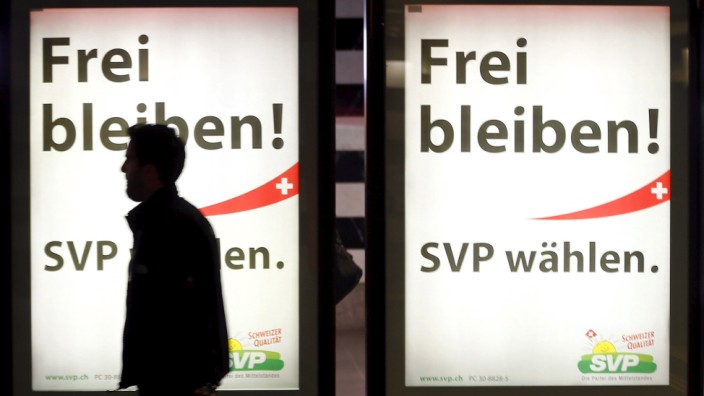 A man walks past election campaign posters of the Swiss People's Party at the main train station in Zurich