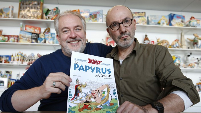 Author Jean-Yves Ferri and illustrator Didier Conrad pose with the front page of their new comic book 'Le Papyrus de Cesar' (Asterix and the Missing Scroll) in Vanves, Southern Paris