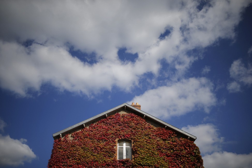 Clouds pass over the Moulin Gautron center that is covered with Virginia creeper on an autumn day in Vertou