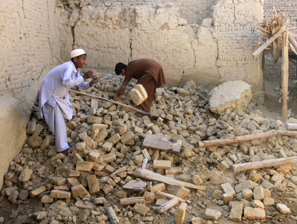 Afghan men clears bricks from a house after it was damaged by an earthquake in Behsud district of Nangarhar province, Afghanistan
