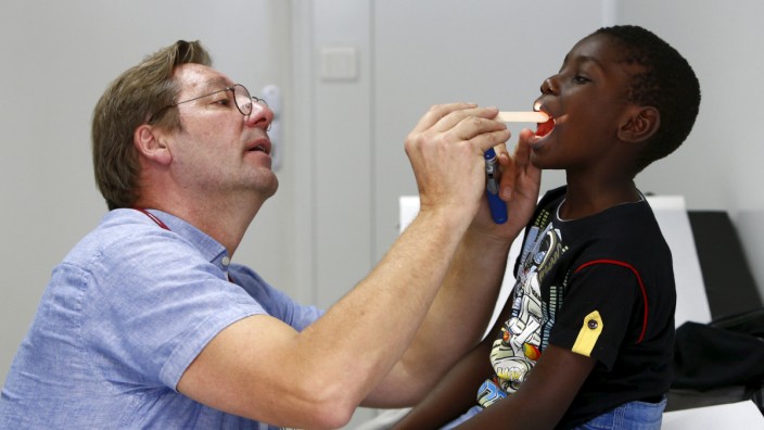 Migrant Kuapana from Congo receives a medical check-up from doctor Mathias Wendeborn, at a refugee camp set-up in the former German army base 'Bayernkaserne' in Munich