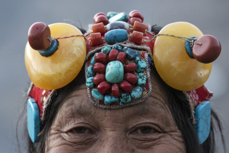 An ethnic Tibetan woman from Kham area wears traditional amber and other stone headwear at the Larung Wuming Buddhist Institute in remote Sertar county, Garze Tibetan Autonomous Prefecture