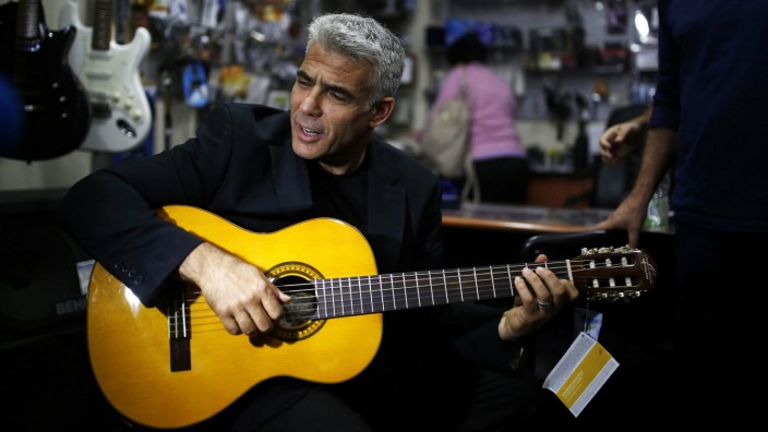 Yair Lapid plays guitar in Ashdod campaign stop