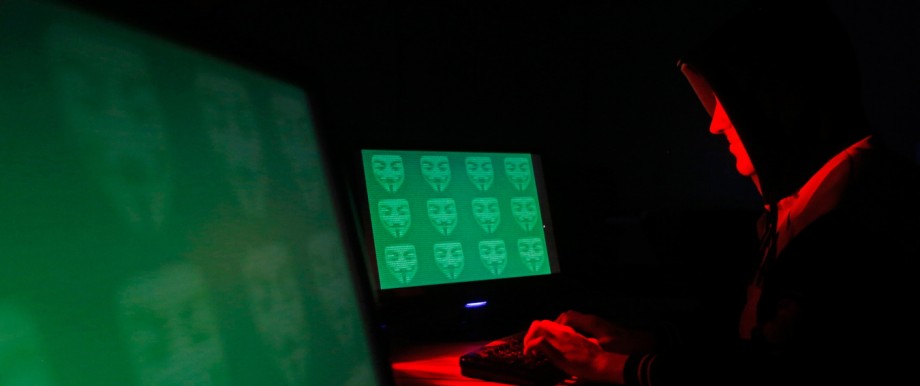 Man poses in front of on a display showing the word 'cyber' in binary code, in this picture illustration taken in Zenica