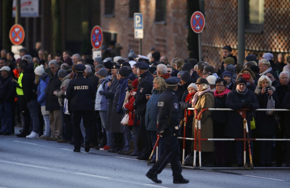 People wait behind a fence during the memorial service for the late former West German Chancellor Schmidt in St. Michael's Church in Hamburg