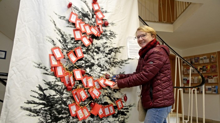 Geschenke für Asylbewerber: Ines Lobenstein mit dem Spendenbaum. Bis 8. Dezember kann man Päckchen abgeben.