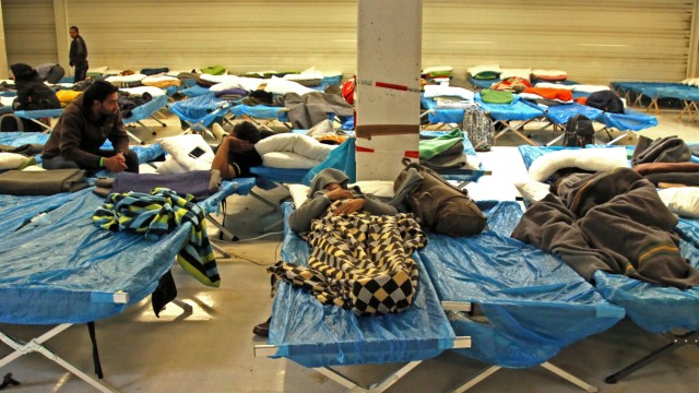 Notunterkunft für Flüchtlinge: Völlig erschöpft fallen viele Männer und Frauen in der Sammelstelle in den Schlaf.