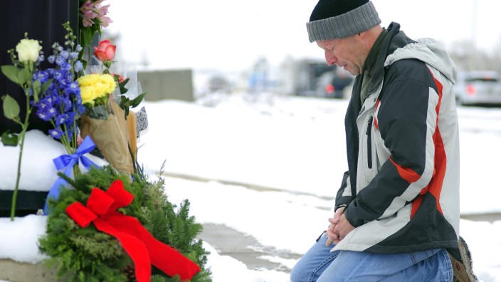 USA: Trauer in Colorado Springs: Nach dem Amoklauf in der Klinik "Planned Parenthood" legt ein Einwohner des Orts Blumen am Tatort nieder.