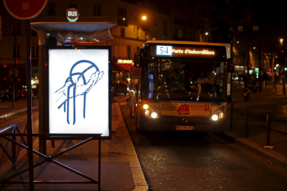 A poster by street artist Paul Insect as part of the 'Brandalism' project is displayed at a bus stop in Paris
