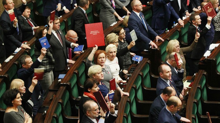 Neue Regierung: Auf einmal nur noch Papier: Die polnische Verfassung wird von Mitgliedern der Opposition im Warschauer Parlament zur Mahnung in die Höhe gehalten.