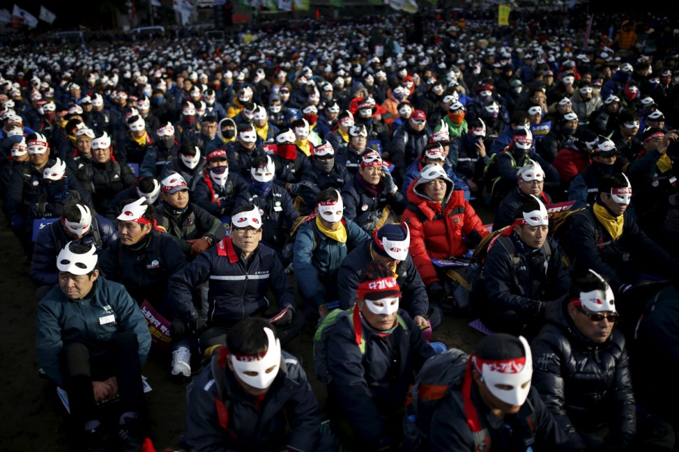 Protesters wearing masks take part in an anti-government rally in central Seoul