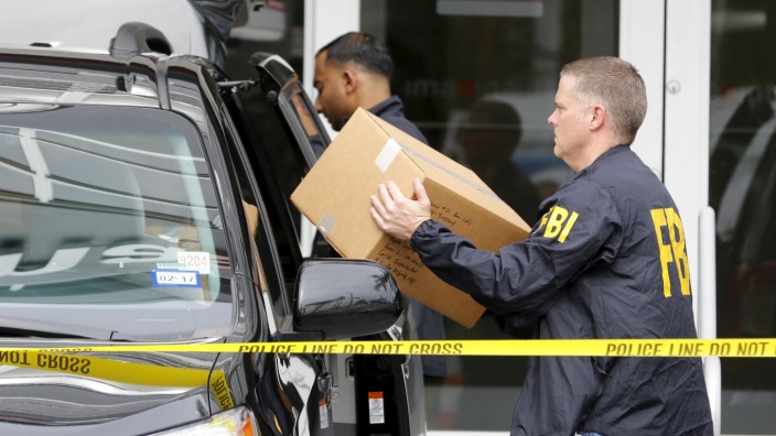 FBI agents remove boxes and other items from the offices of Imagina in Miami