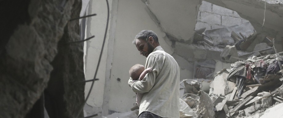 A man carries a child who survived what activists said were airstrikes by forces loyal to Syria's President Bashar al-Assad, in the Douma neighborhood of Damascus
