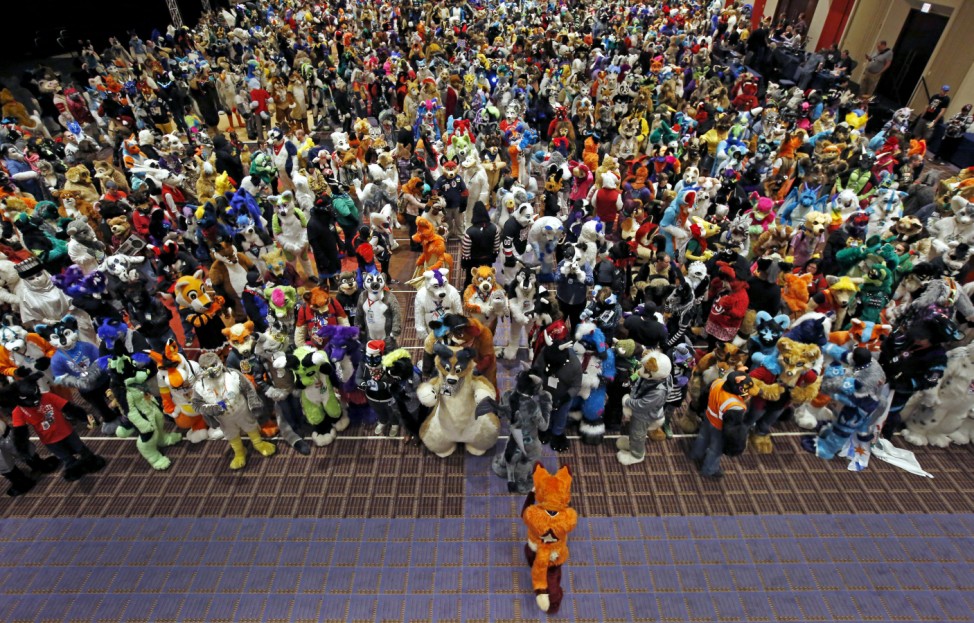 An attendee dress up as a fox moves into position for a group photo at the Midwest FurFest in the Chicago suburb of Rosemont, Illinois, United States