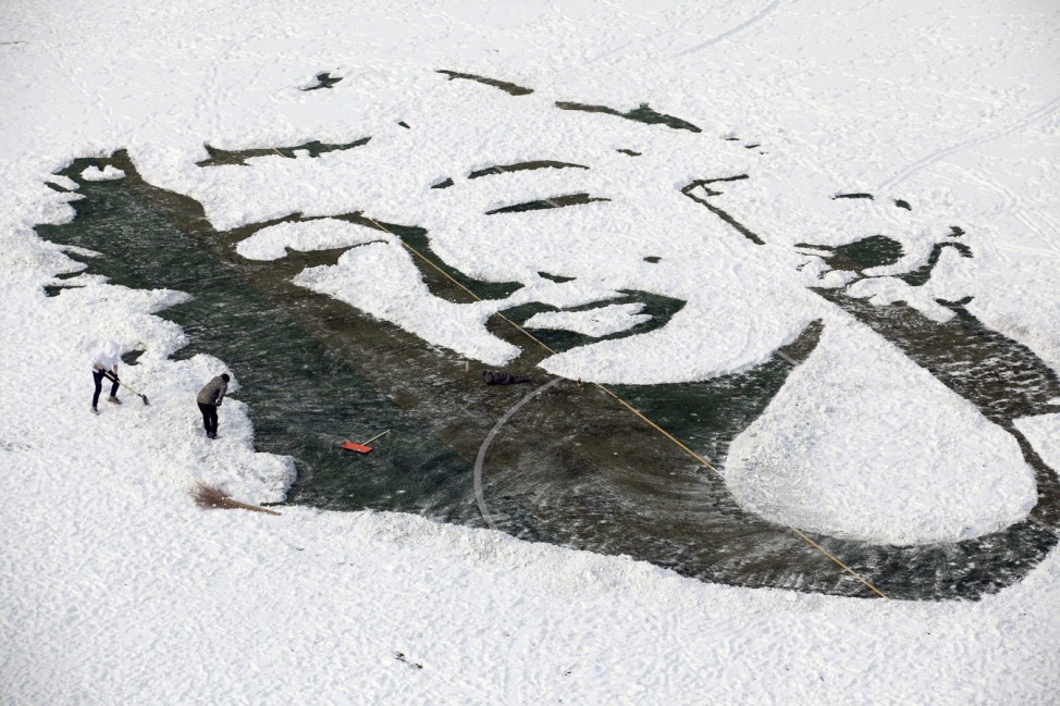 University students create an image of Marilyn Monroe by clearing snow on a soccer pitch, in Changchun