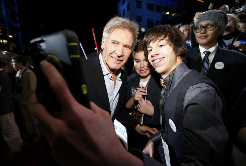 Actor Harrison Ford poses for a fan as he arrives at the premiere of 'Star Wars: The Force Awakens' in Hollywood