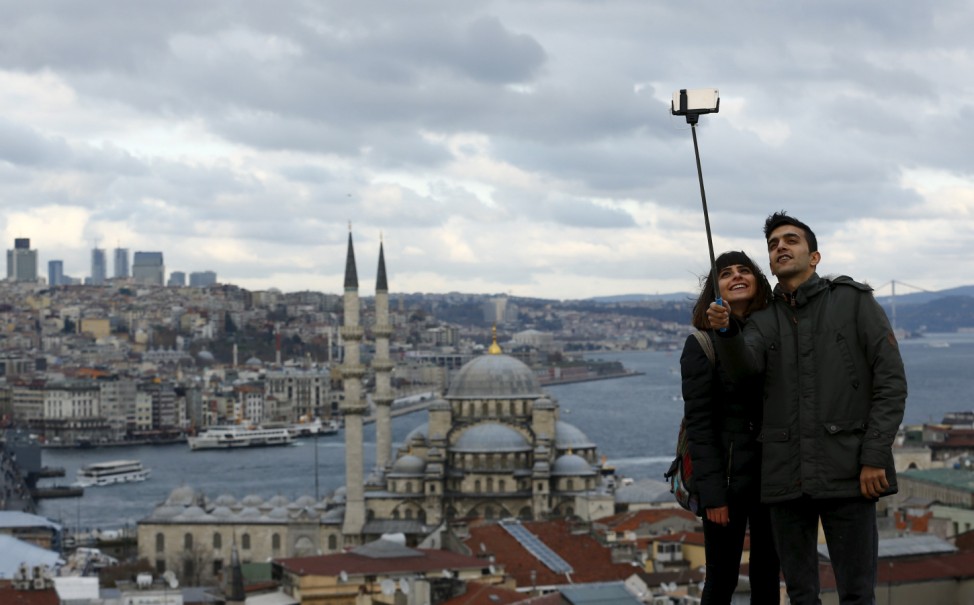 People take a selfie with the Bosphorus in the background in Istanbul, Turkey