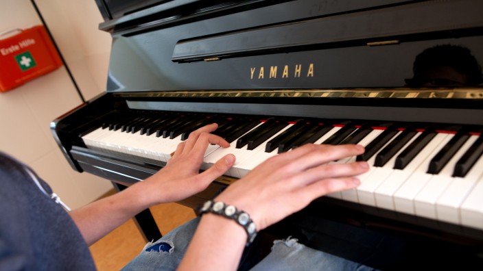 Klavierspieler im Kinderhaus der Johanniter, Junge aus einer sozial schwachen Familie.