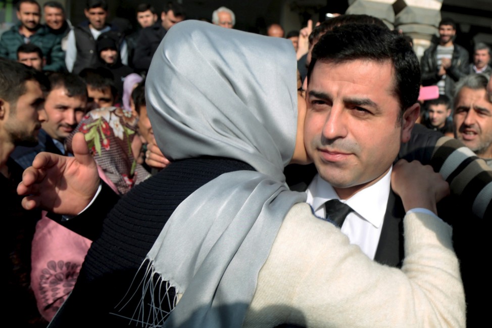 Demirtas, co-leader of the pro-Kurdish Peoples' Democratic Party (HDP), is hugged by a supporter as he leaves from the party headquarters in the southeastern city of Diyarbakir, Turkey