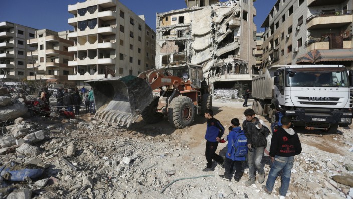 Boys inspect a site that was hit by an Israeli strike, killing a Lebanese militant leader Samir Qantar, in the Damascus district of Jaramana