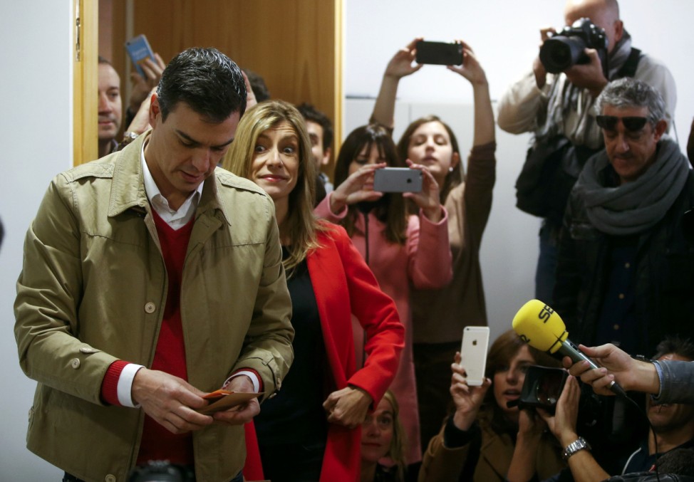 Spain's Socialist Party (PSOE) leader Pedro Sanchez prepares to vote at a polling station with his wife Begona during voting in Spain's general election in Pozuelo de Alarcon, near Madrid