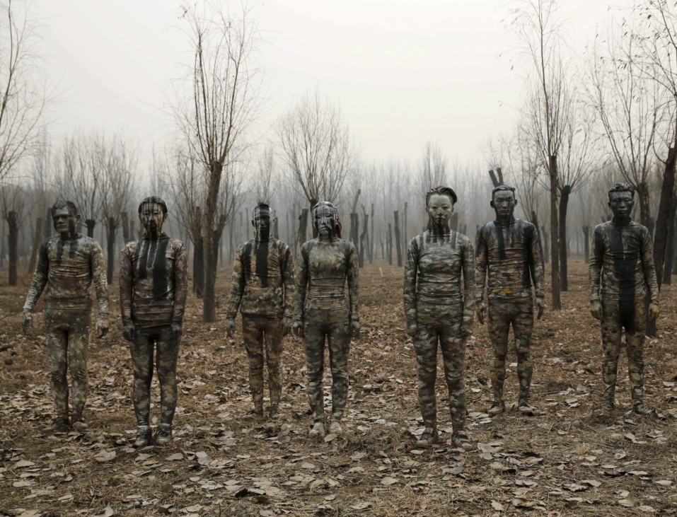 Models painted in camouflage colours to blend in with the background pose for Chinese artist Liu Bolin's artwork 'Dongji', or Winter Solstice, in Beijing