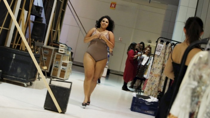 Model runs backstage before a presentation as part of Fashion Weekend Plus Size Summer 2015 collection show in Sao Paulo