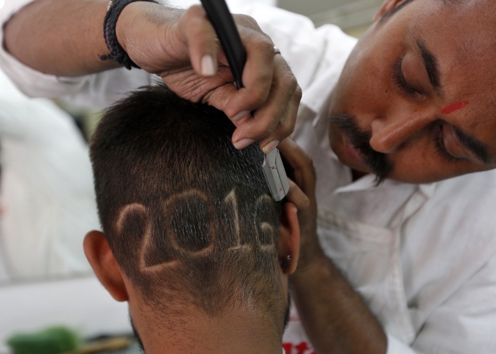 A man gets a haircut depicting 2016 to welcome the New Year at a barbershop in Ahmedabad