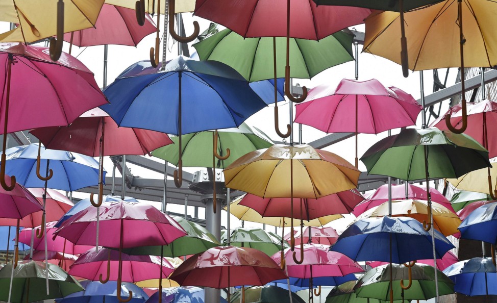 A sculpture constructed of umbrellas is seen in the rain in a street in central London