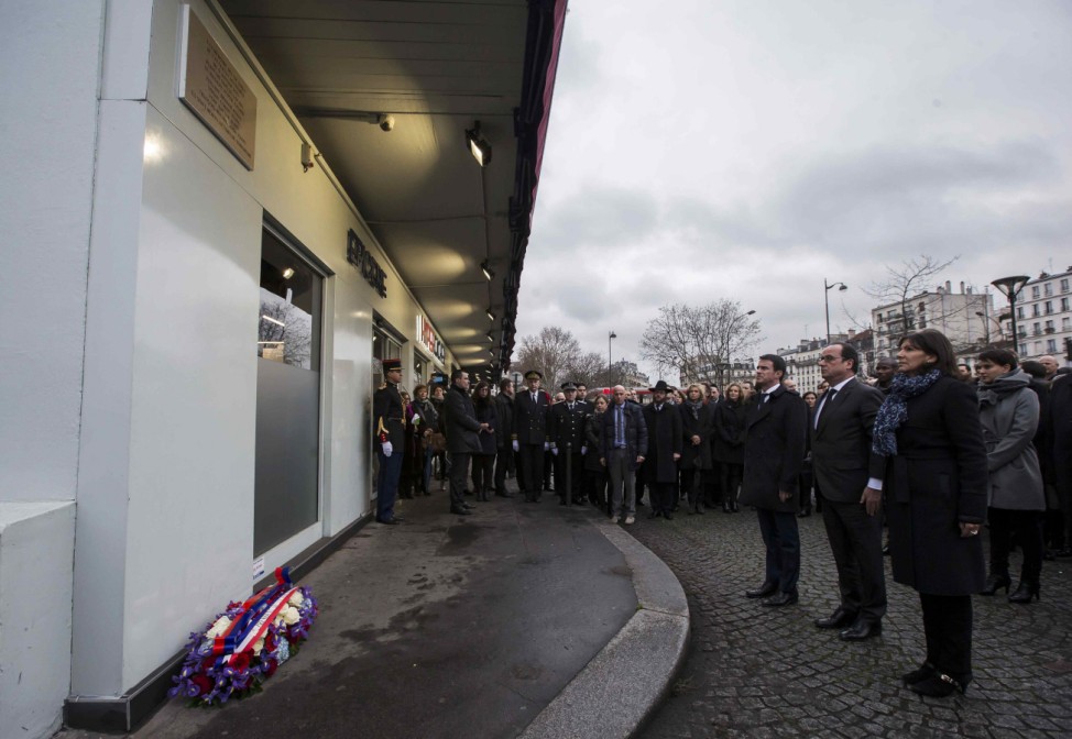 French President Hollande, French Prime Minister Valls and Mayor of Paris Hidalgo stand at attention after unveiling a commemorative plaque outside the Hypercacher kosher supermarket in Paris