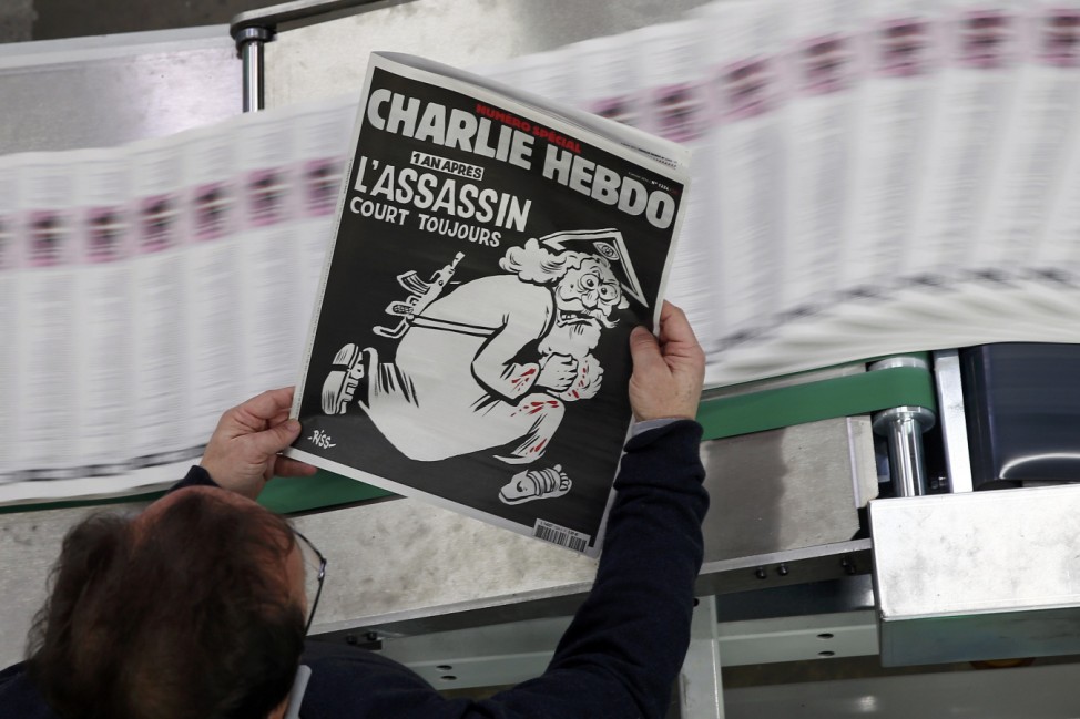 An employee of a printing house holds a copy of the latest edition of French weekly newspaper Charlie Hebdo near Paris
