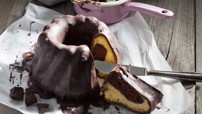 Marble cake piece of chocolate cake and knife on greaseproof paper PUBLICATIONxINxGERxSUIxAUTxHUNxO
