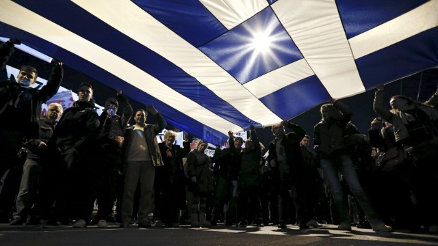 File photo of protesters holding a giant Greek national flag during an anti-austerity and pro-government demonstration in front of the parliament in Athens