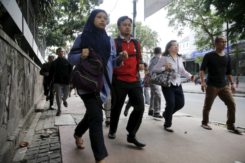 Indonesian workers run as they are evacuated from their office at Thamrin business district in Jakarta