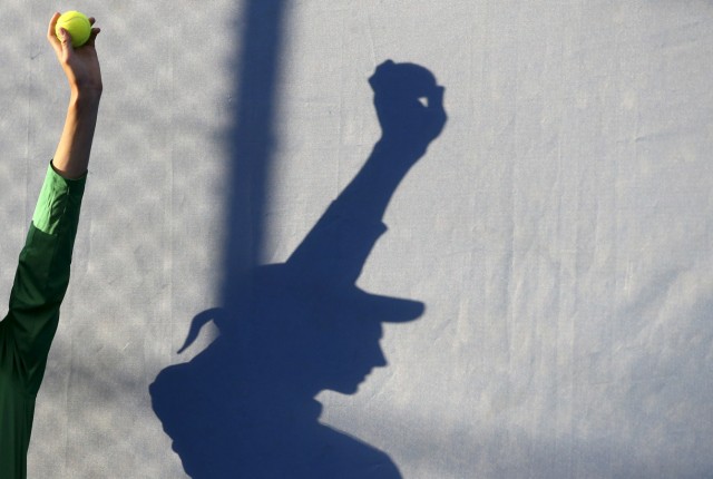 A ball boy is silhouetted as he holds up a tennis ball during a match at the Australian Open tennis tournament at Melbourne Park, Australia